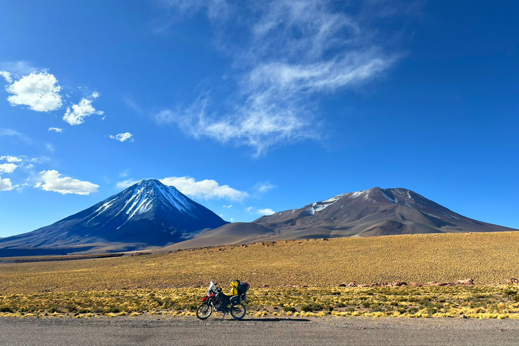 Motocicleta em frente aos vulcões Licancabur e Juriques, no lado chileno da Cordilheira dos Andes